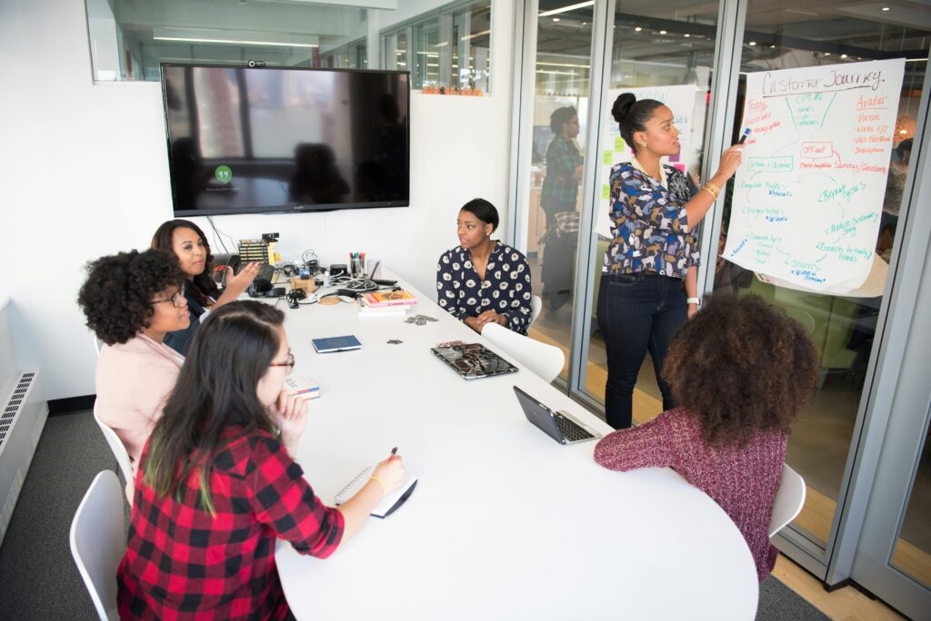 A multicultural office team engages in a collaborative brainstorming session around a conference table.